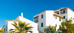 Edificio de apartamentos modernos en una zona residencial con jardines y palmeras