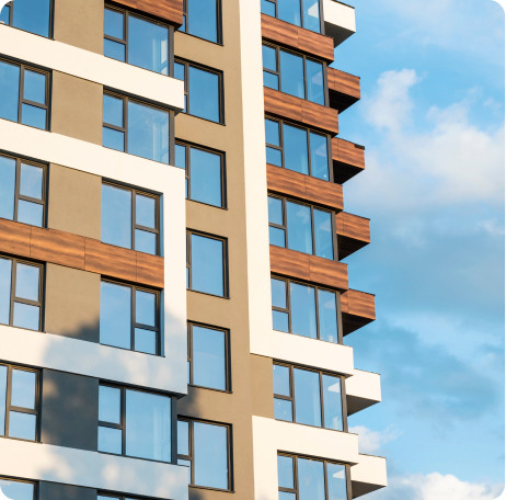 Fachada de edificio residencial de obra nueva con balcones y cielo azul